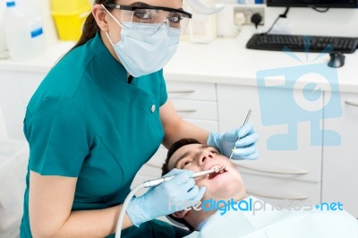 Dentist Examining Mouth Of Patient Stock Photo