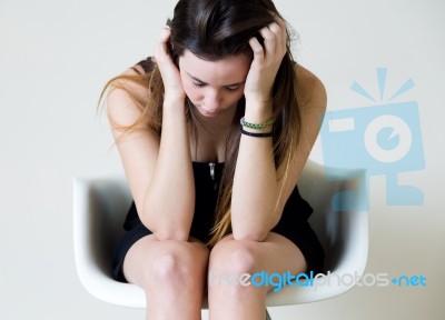 Depressed Young Woman Sitting At Home Stock Photo