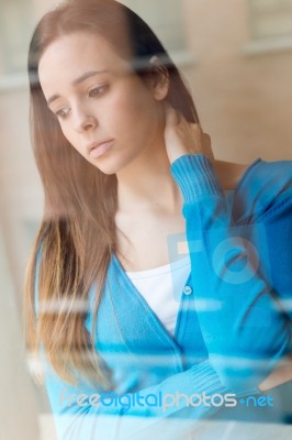 Depressed Young Woman Sitting At Home Stock Photo