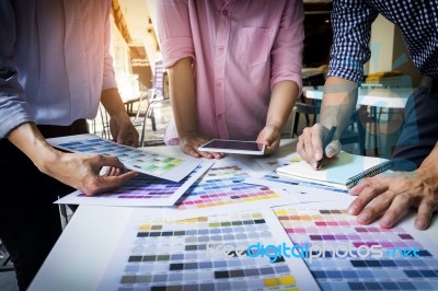 Designers Working Together At Desks In Modern Office Stock Photo