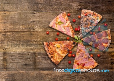 Diferents Types Of Pizza Cut On Wooden Table Stock Photo