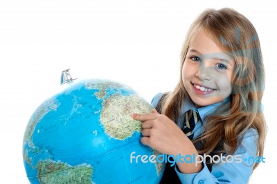 Disciplined Child Pointing At Something On Globe Stock Photo