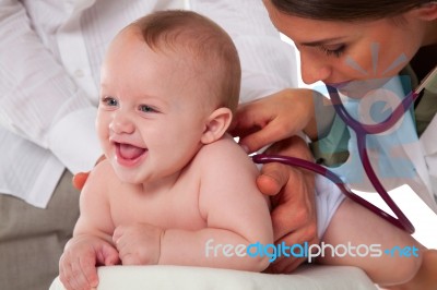 Doctor Listening To Toddler's Back With Stethoscope Stock Photo