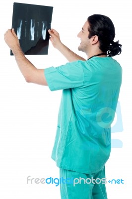 Doctor Looking At Scanned X-ray Report Stock Photo