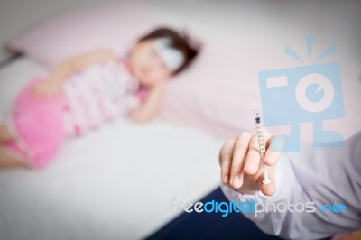 Doctor Preparing An Injection For A Little Asian Girl Stock Photo