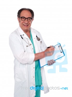 Doctor Writing Medical Report Stock Photo