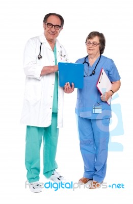 Doctors Analyzing Report Together Stock Photo