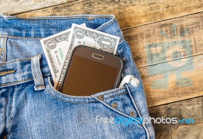 Dollar Money And Smart Phone In Pocket Blue Jeans Stock Photo