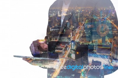 Double Exposure Of A Businessman And A City Using A Tablet Over Stock Photo