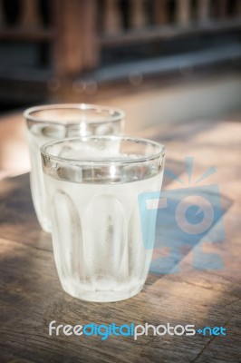 Double Glasses Of Cold Water On Wooden Table Stock Photo