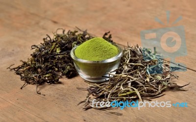 Dried Tea Leaf And Powder On Wooden Background Stock Photo