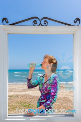 Drinking Woman In Window At Sea Stock Photo