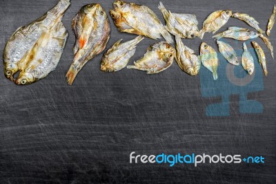 Dry Fish With Sunny On Black Wooden Floor Stock Photo