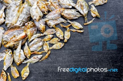 Dry Fish With Sunny On Black Wooden Floor Stock Photo