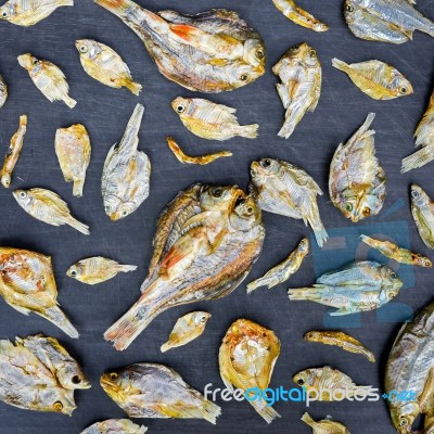 Dry Fish With Sunny On Black Wooden Floor Stock Photo