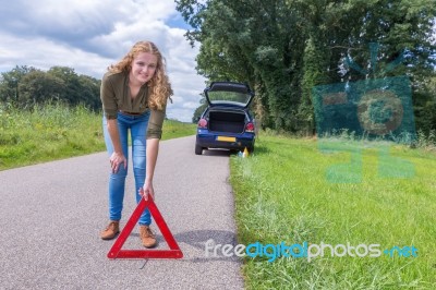 Dutch Woman Placing Warning Triangle On Rural Road Stock Photo