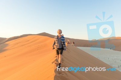 Early Morning Climbers On Sand Dune Near Sossusvlei, Namibia Stock Photo