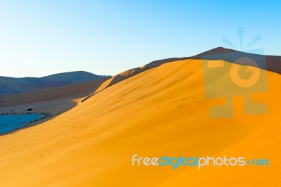 Early Morning Climbers On Sand Dune Near Sossusvlei, Namibia Stock Photo