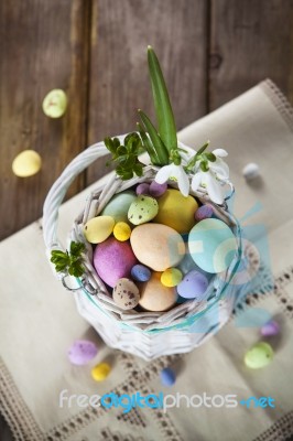 Easter Eggs In The White Basket On Rustic Wooden Background Stock Photo