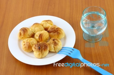 Eclairs On Plate On Wooden Table Adn Fresh Water Stock Photo