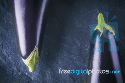 Eggplants On The Dark Stone Background Top View Stock Photo