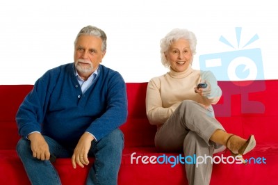 Elderly Couple Sitting In Sofa Stock Photo