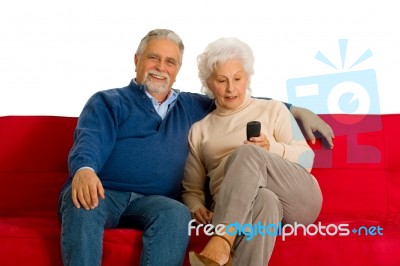 Elderly Couple With Remote Control Stock Photo