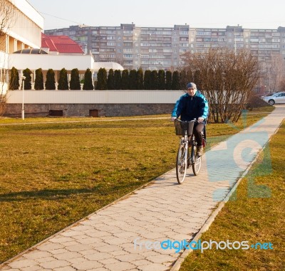 Elderly Man Wearing Glasses Riding A Bicycle Stock Photo