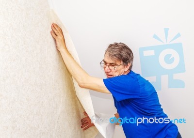 Elderly Worker Attaching Wallpaper Stock Photo