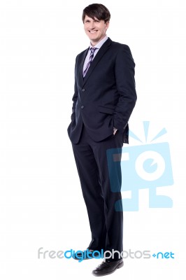 Elegant Businessman Stood With Hands In Pockets Stock Photo