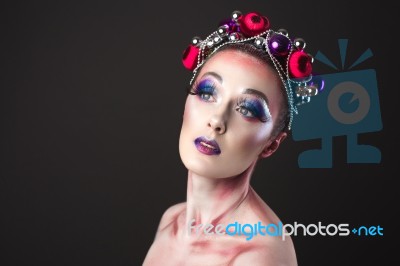 Elegant Model With Bright New Year's Eve Make-up In A Wreath Of Christmas Toys Stock Photo