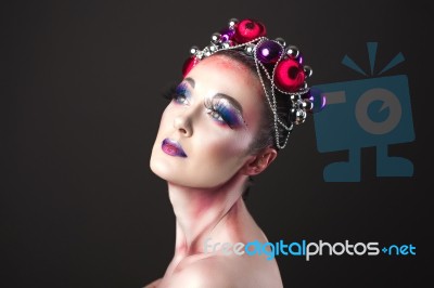 Elegant Model With Bright New Year's Eve Make-up In A Wreath Of Christmas Toys Stock Photo