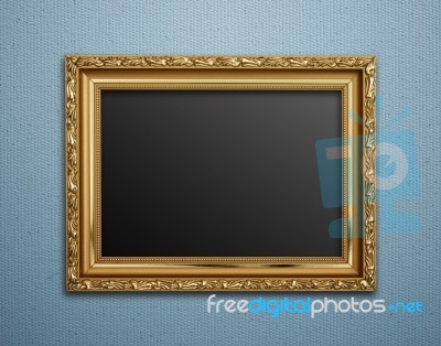 Empty Golden Vintage Frame On Wallpaper Background Stock Photo