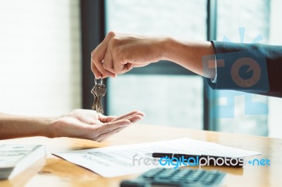 Estate Agent Giving House Keys To Man And Sign Agreement In Offi… Stock Photo