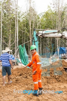 Excavator And Workers Stock Photo