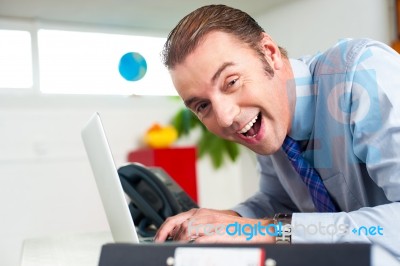 Excited Businessman Working On Laptop Stock Photo