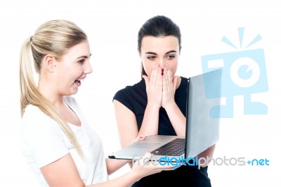 Excited Girls Watching Videos On Laptop Stock Photo