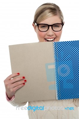 Excited Teen Girl Holding Note Book Close To Her Stock Photo