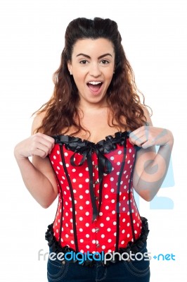 Excited Woman Adjusting Her Polka Dotted Corset Top Stock Photo