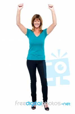 Excited Woman In Celebration Mood With Raised Arms Stock Photo