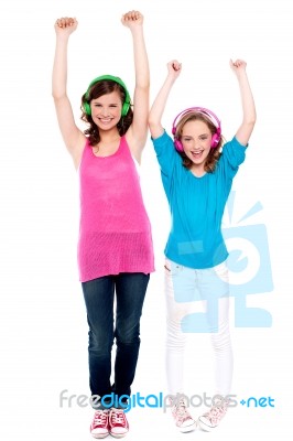 Excited Young Girls Enjoying Music Stock Photo