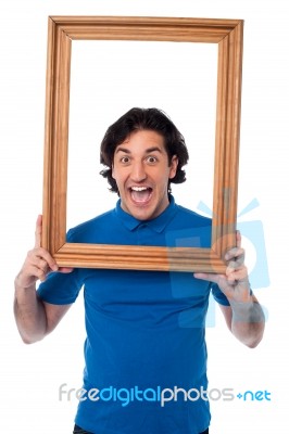 Excited Young Male Holding Wooden Frame Stock Photo