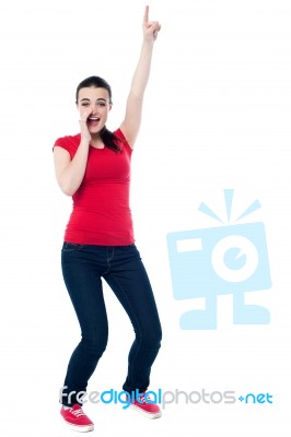 Excited Young Woman Pointing Upwards Stock Photo