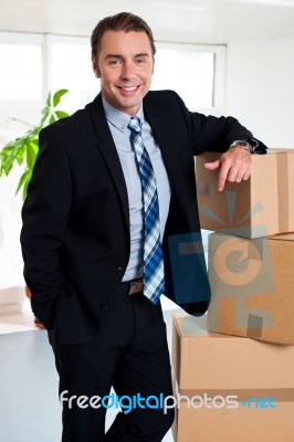 Executive With His Hand Placed On Pile Of Cardboard Cartons Stock Photo