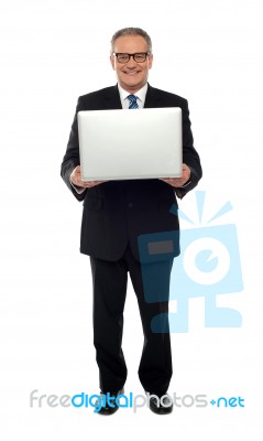 Experienced Business Person Holding Laptop Stock Photo