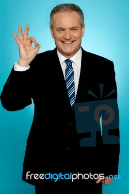 Experienced Businessman Showing Okay Sign Stock Photo