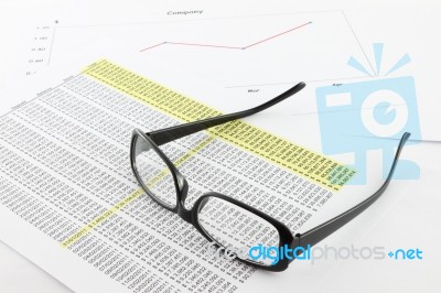 Eye glasses on financial report Stock Photo