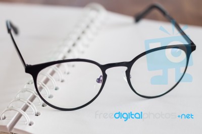 Eyeglasses On Opened Spiral Notebook Stock Photo