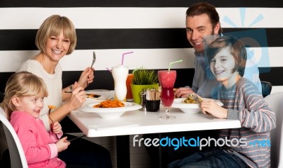 Family Eating Lunch Together In Restaurant Stock Photo