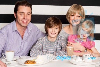 Family Enjoying Breakfast At Restaurant Stock Photo